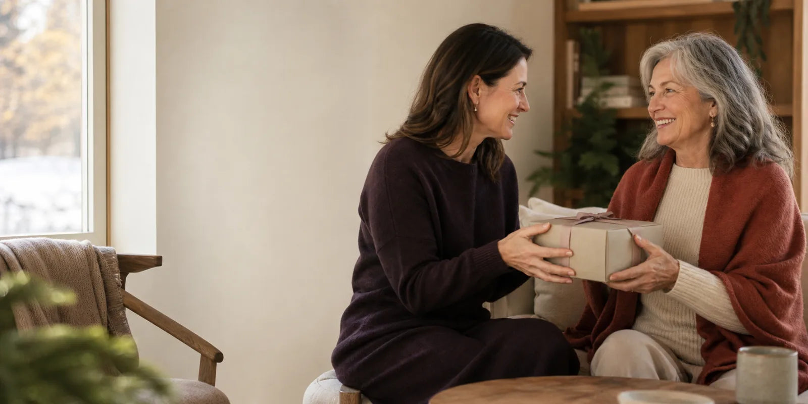 Two women exchanging a wrapped gift