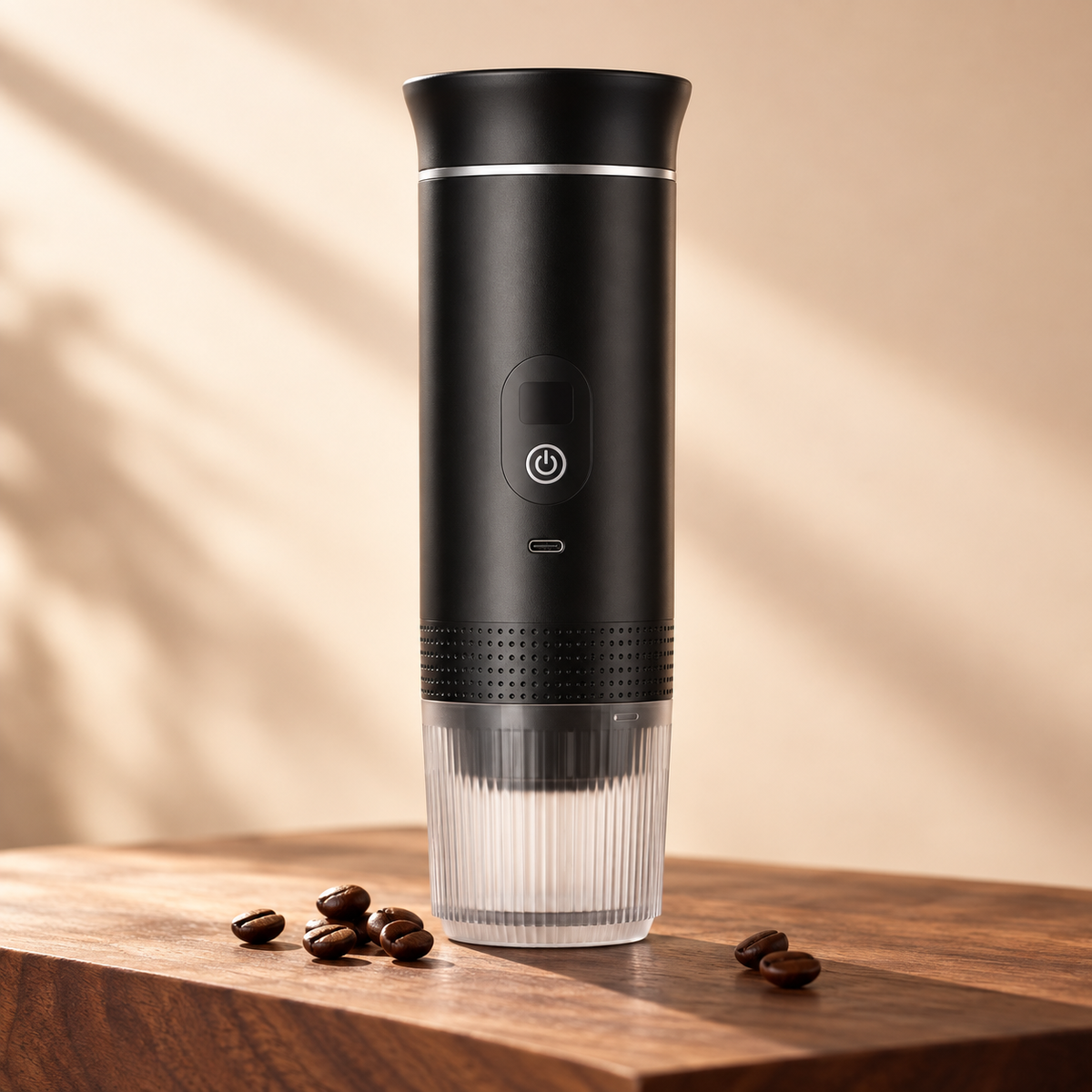 Black portable espresso maker with its attached ribbed cup on a coffee-colored studio surface
